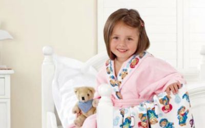 kleines Mädchen im Bademantel mit Teddy